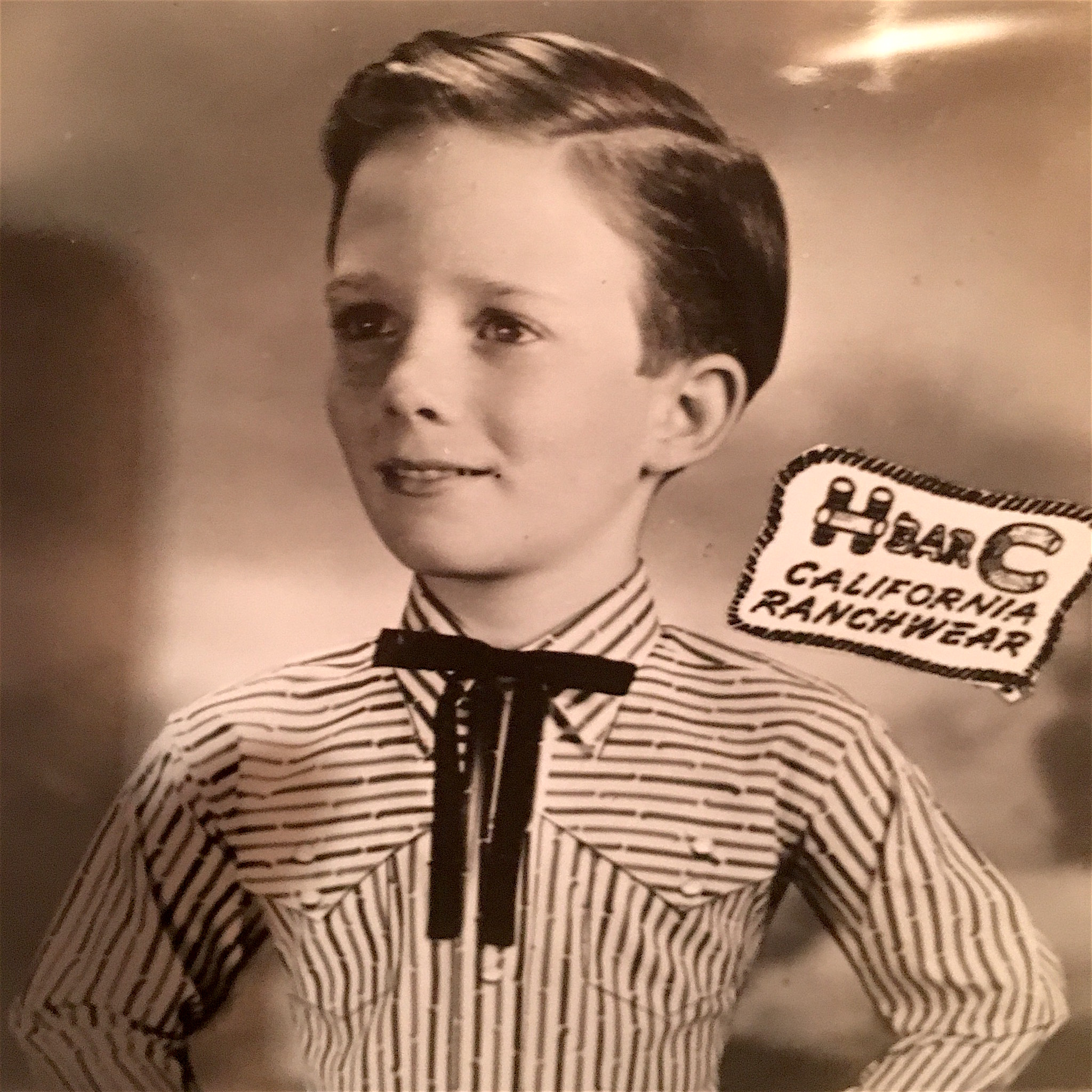 Child modeling in an H-Bar-C California Ranchwear shirt with a black string tie